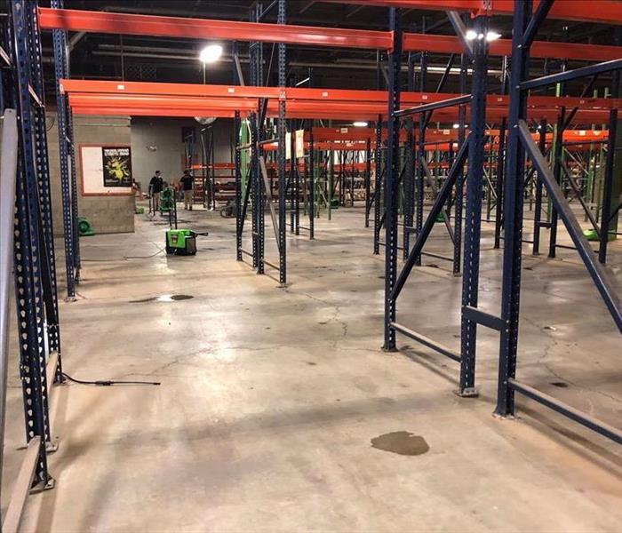 warehouse interior with metal shelving and green equipment