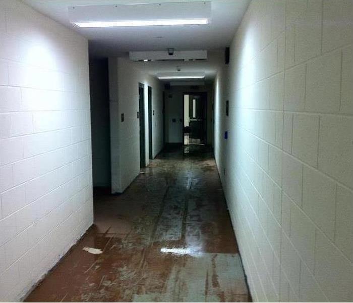 water on floor, concrete block walls in corridor