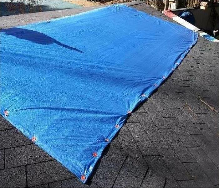 blue tarp covering a roof.
