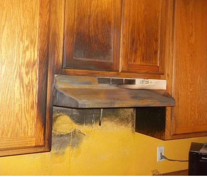 smoke and fire damaged grown cabinets over a hood