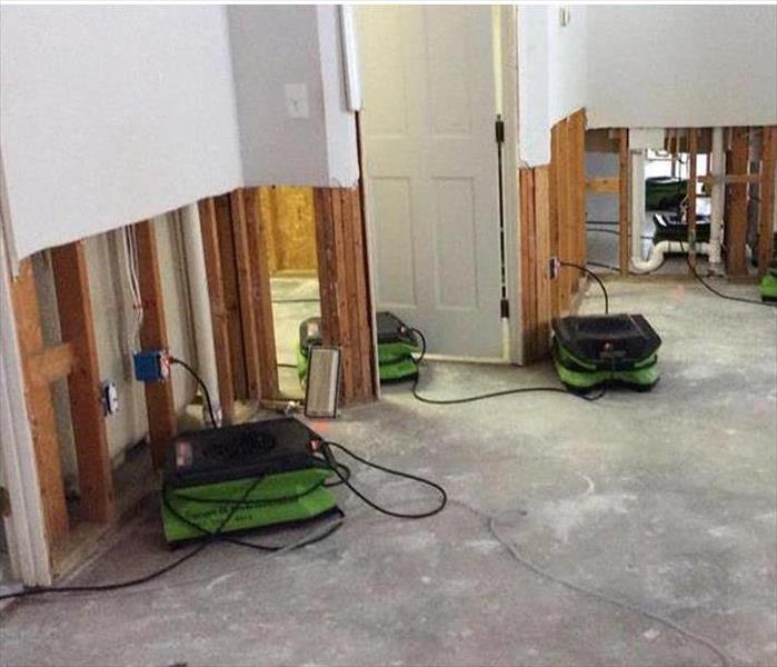 drying air movers, cut out walls showing plumbing lines, concrete floor