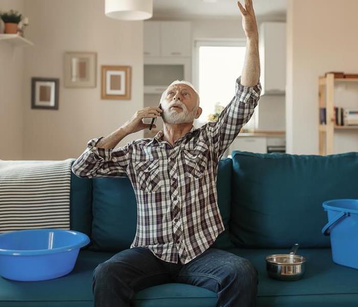 A man holding buckets up in a living room.